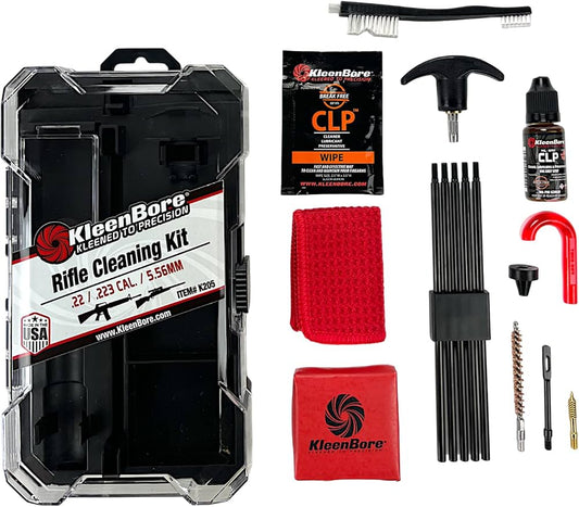 KleenBore Rifle Cleaning Kit shown in a clear plastic case with multiple included cleaning tools and accessories arranged beside it on a white background, including brushes, a black cleaning rod set, a red cloth, a red pouch, a bottle, wipes, and other cleaning accessories.
